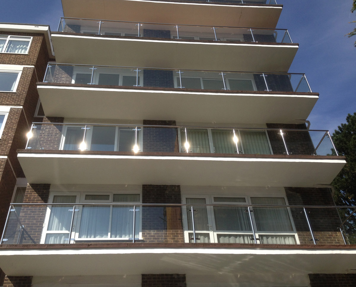 New stainless steel balustrades with glass infills to a large block of flats in Dorset.