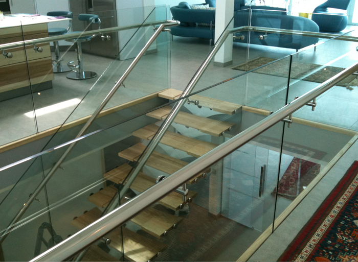 Centre spine staircase with timber treads and structural glass balustrading to a new contemporary dwelling.