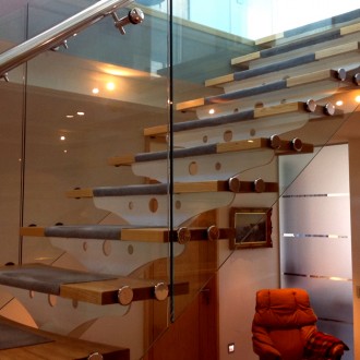Centre spine staircase with timber treads and structural glass balustrading to a new contemporary dwelling.