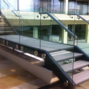 Contemporary mild steel exterior staircase with stainless steel handrails and structural glass balustrade.