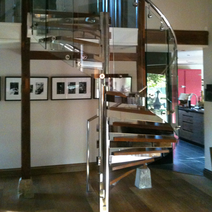 Stainless steel glass spiral staircase with oak timber treads.