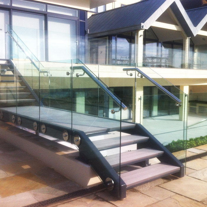 Contemporary mild steel exterior staircase with stainless steel handrails and structural glass balustrade.