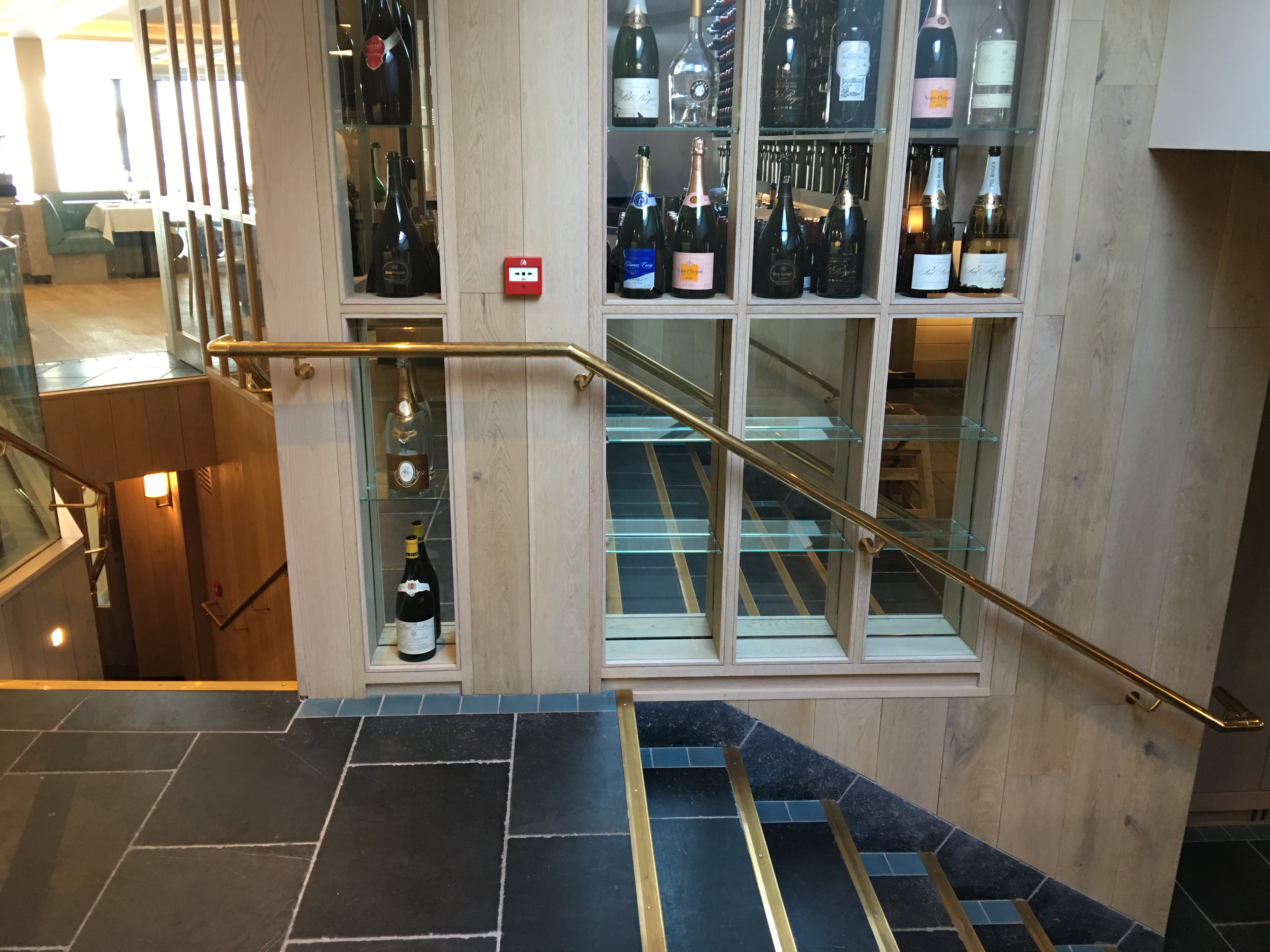 Mild steel staircase with brass handrails and structural glass balustrading.