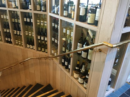 Mild steel staircase with brass handrails and structural glass balustrading.