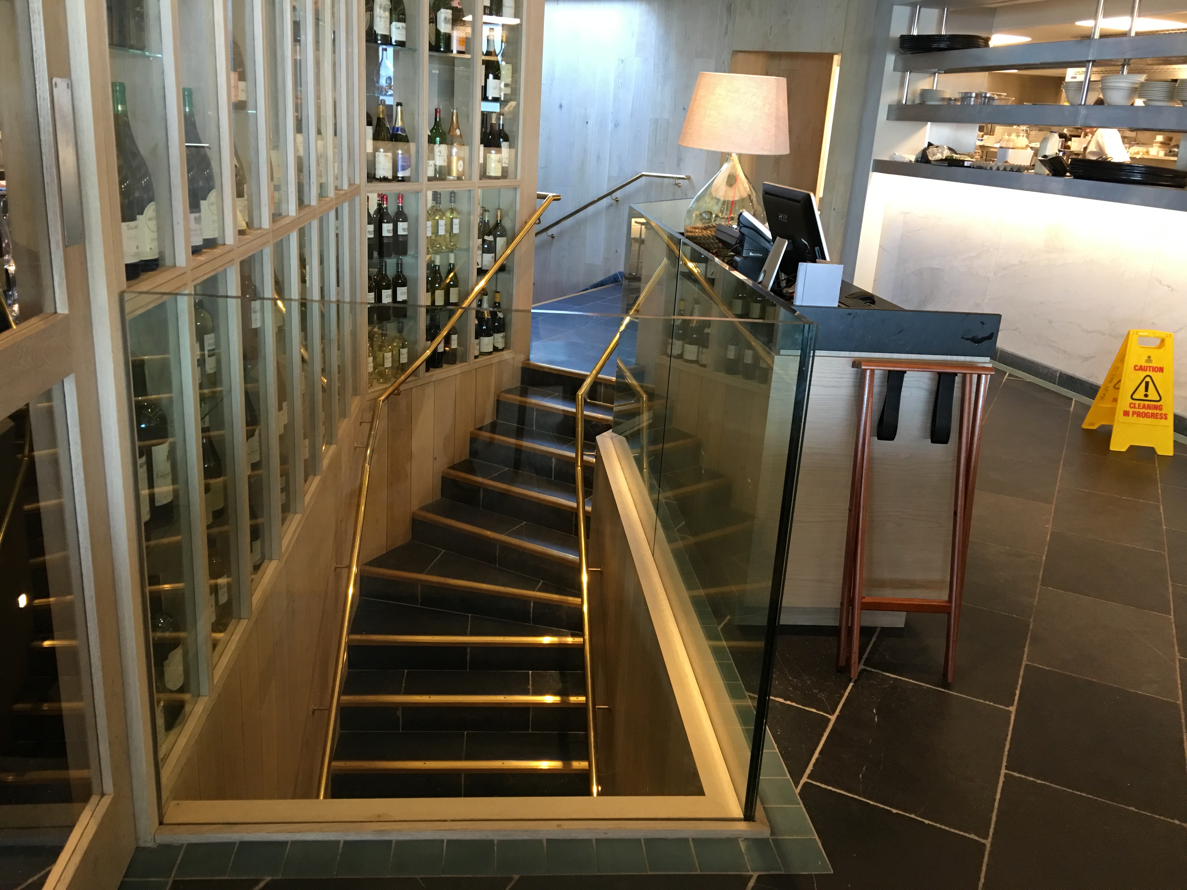 Mild steel staircase with brass handrails and structural glass balustrading.