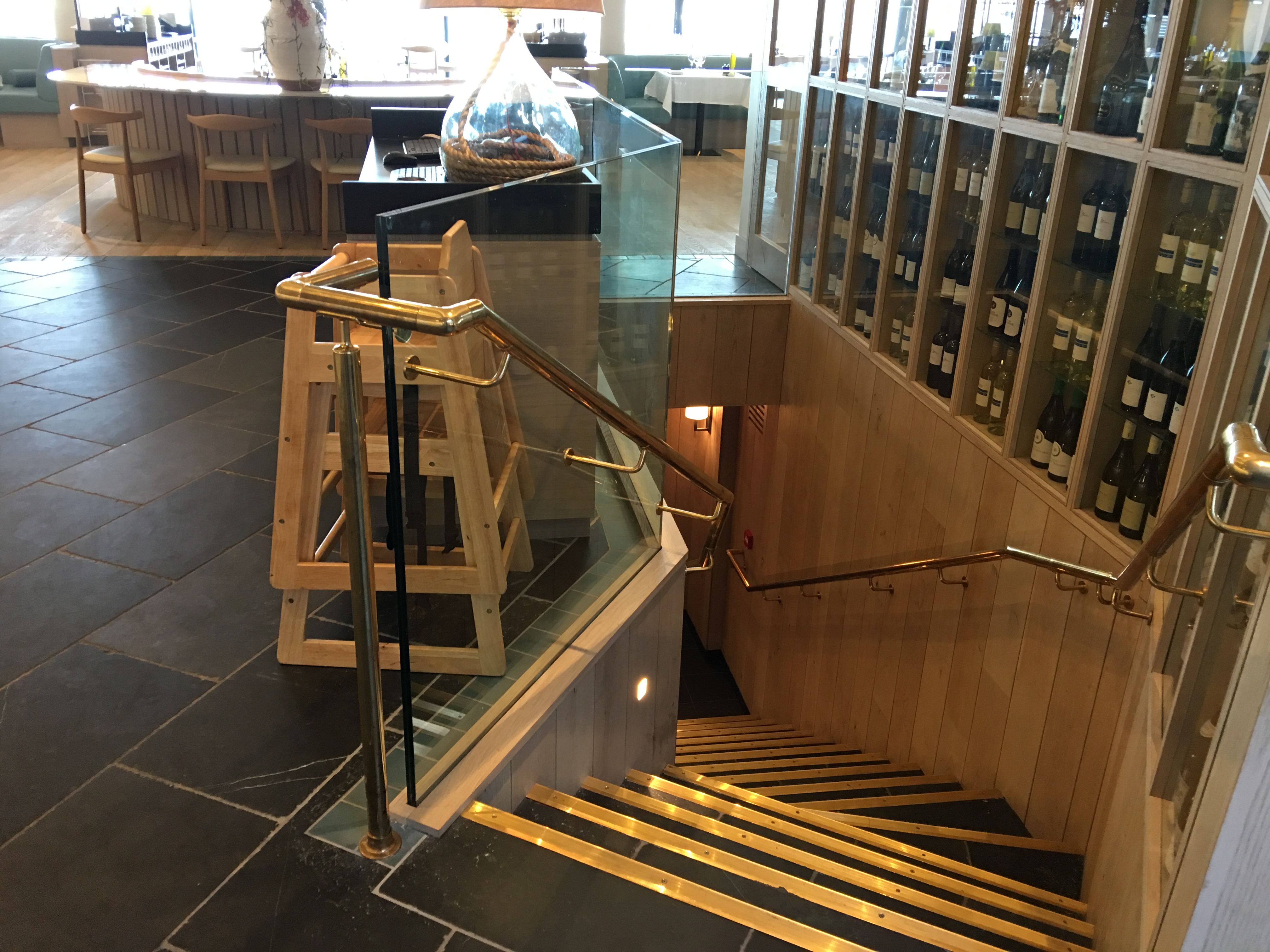Mild steel staircase with brass handrails and structural glass balustrading.