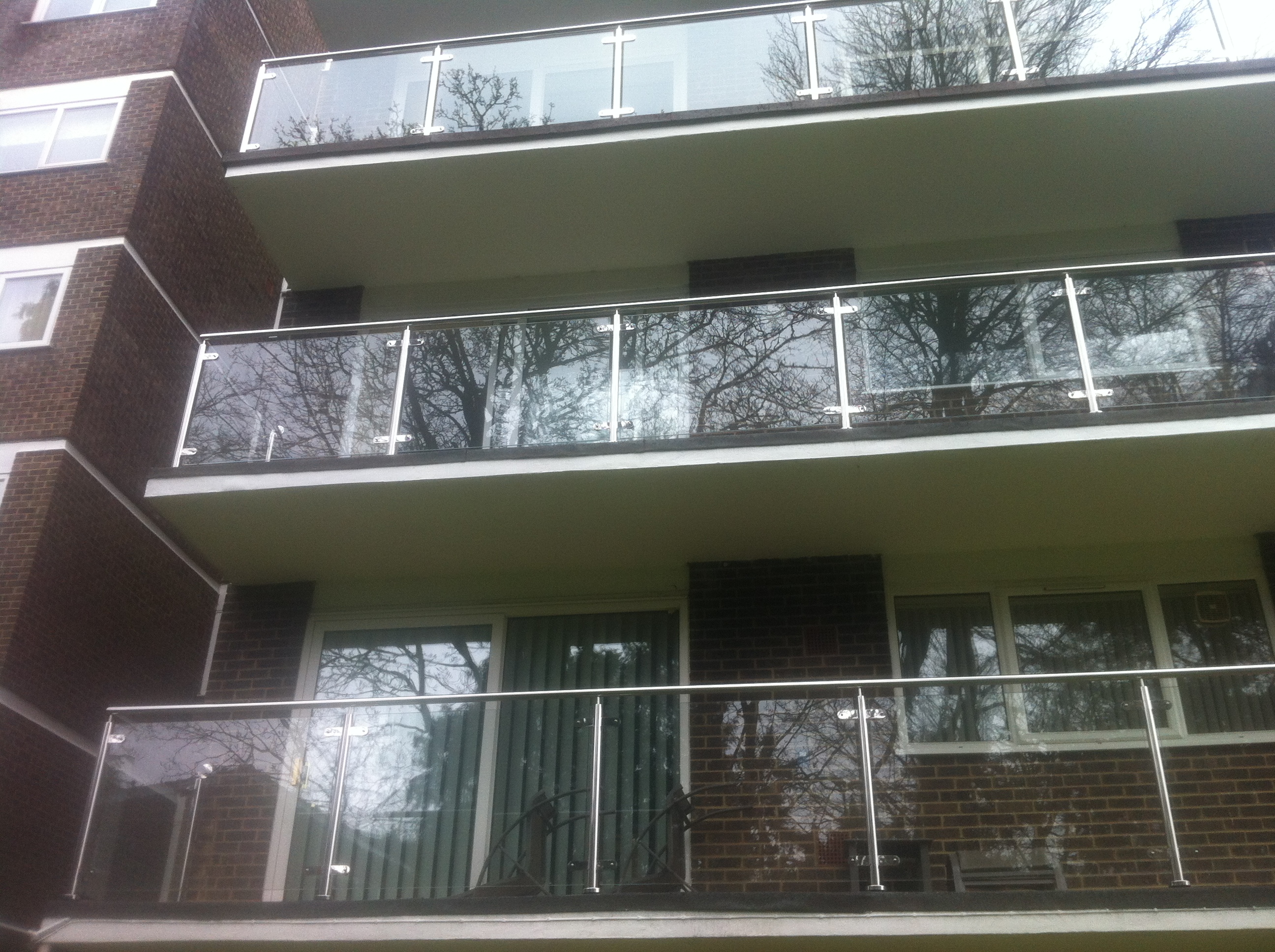 New stainless steel balustrades with glass infills to a large block of flats in Dorset.