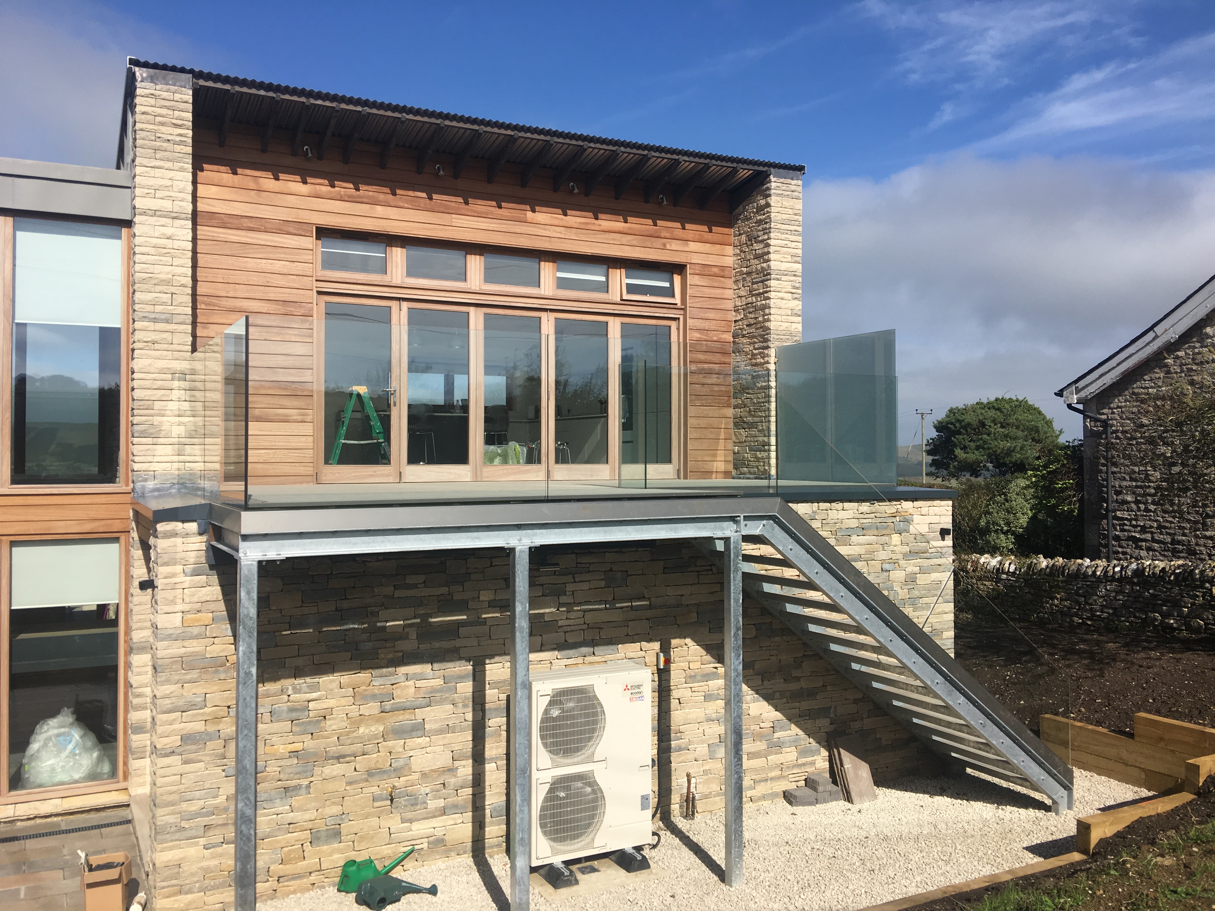 Contemporary exterior galvanised staircase with structural glass balustrading.